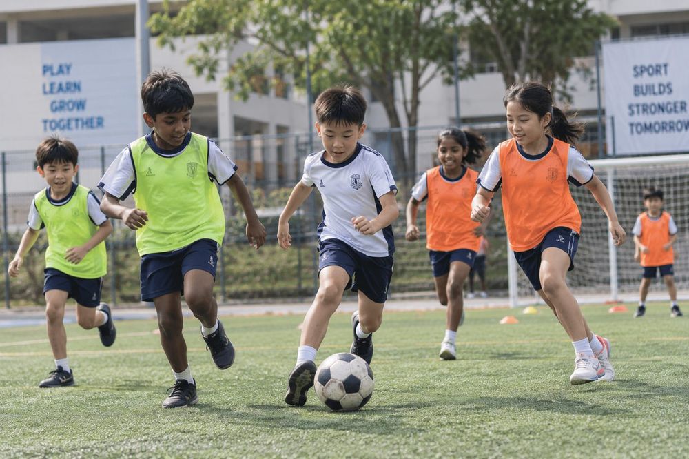 Students playing Football / Soccer during a Momentum Academy programme in Singapore