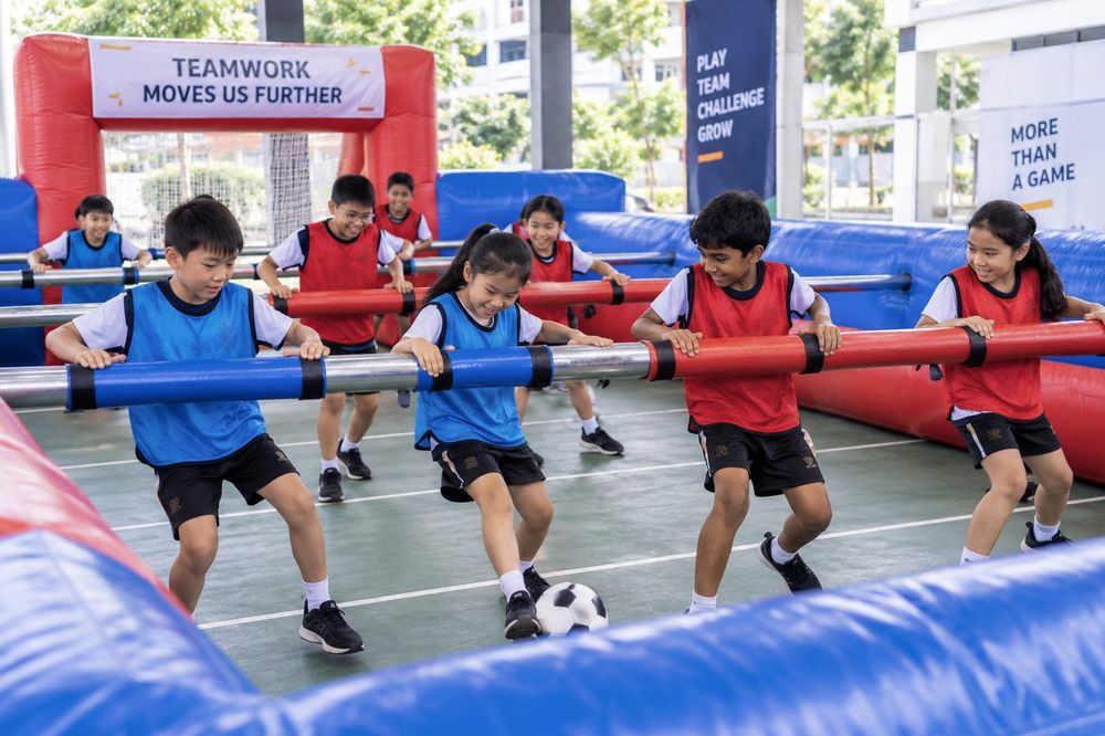 Students playing Human Foosball during a Momentum Academy programme in Singapore