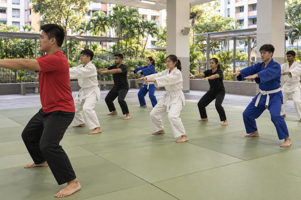Students practising Judo techniques with a Momentum Academy coach in Singapore