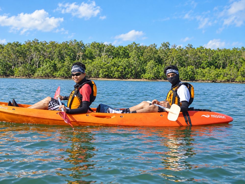 Participants paddling kayaks on calm water during a Kayaking session with Momentum Academy in Singapore